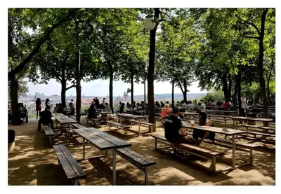 a group of people sitting on benches in a park at Apartments With The Lions in Prague