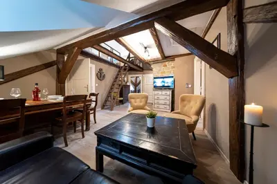 a living room with a table and chairs and a staircase at Old Town - Aparthotel Michalska in Prague