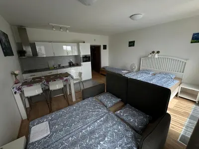 a living room with two beds and a kitchen at Apartments in Residence Garden Towers in Prague