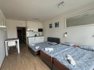 a large bedroom with two beds and a kitchen at Apartments in Residence Garden Towers in Prague