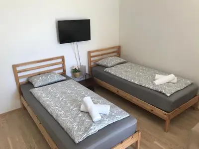 two beds in a room with a flat screen tv at Apartments in Residence Garden Towers in Prague