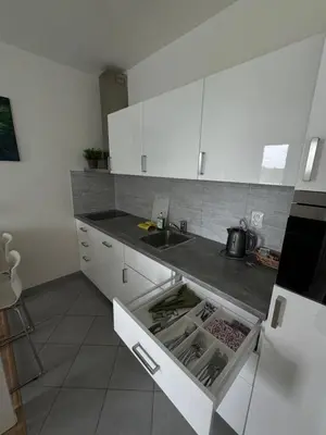 a kitchen with white cabinets and a sink at Apartments in Residence Garden Towers in Prague
