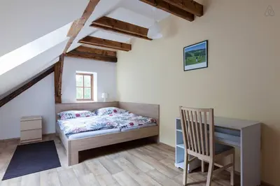 a bedroom with a bed and a desk and a chair at Hájovna Bukovec in Bukovec