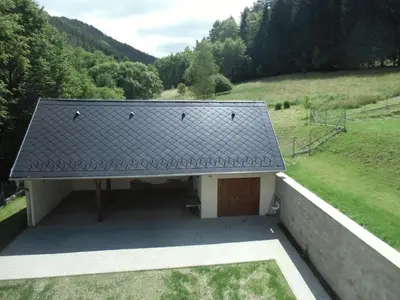 a building with a garage with a roof at Hájovna Bukovec in Bukovec