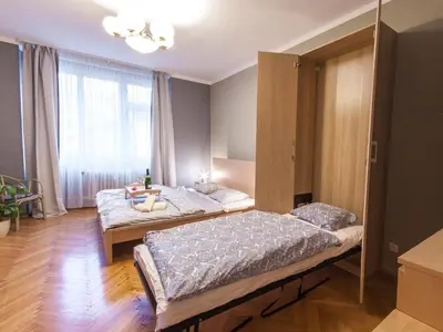 a bedroom with two beds and a large window at Modern Central Apartment Dlouhá in Prague