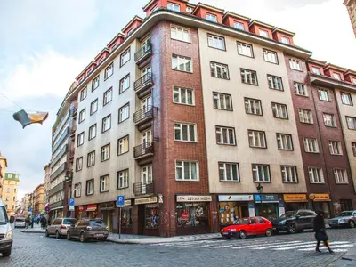 a large brick building on a city street with cars at Modern Central Apartment Dlouhá in Prague