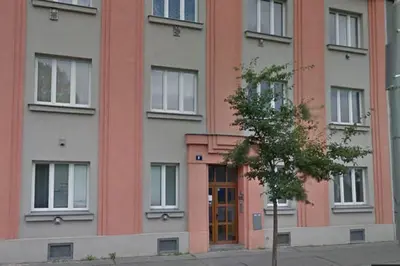 a building with a door and a tree in front of it at Apartment Argentinská 8 in Prague