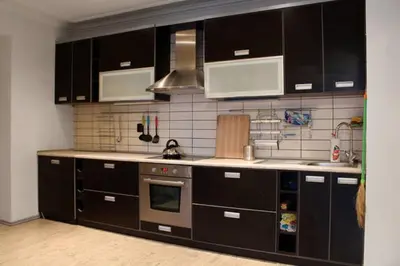 a kitchen with black cabinets and stainless steel appliances at Apartment Argentinská 8 in Prague