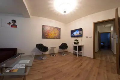 a living room with a glass table and two chairs at Prague Gate Apartments in Prague