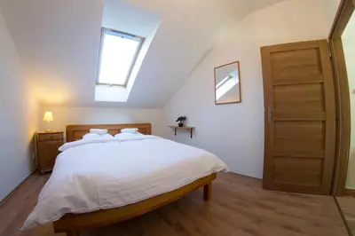 a bedroom with a large white bed with a skylight at Prague Gate Apartments in Prague