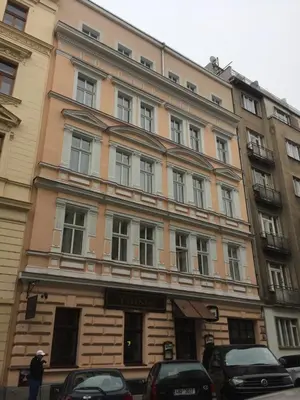 a large building with cars parked in front of it at Prague Gate Apartments in Prague