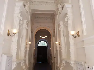 a hallway with white columns and a black door at Charles apartment in Prague