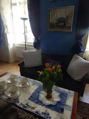 a living room with a table with a vase of flowers at Miraculous Appartement in Prague