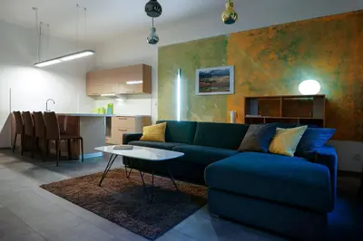 a living room with a blue couch and a kitchen at Apartments At The Blue Duckling in Prague