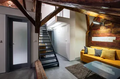 a living room with a yellow couch and a staircase at Apartments At The Blue Duckling in Prague