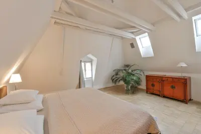 a bedroom with a large bed and a dresser and windows at Eclectic Loft with Terrace in Prague