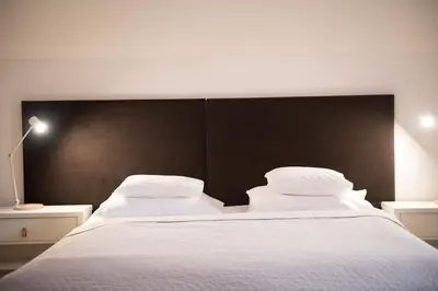 a bedroom with a large white bed with a black headboard at Eclectic Loft with Terrace in Prague
