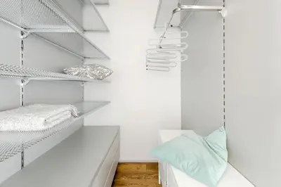 a white room with white shelves and a bed at Prague Days - One-bedroom Apartment with Workspace and iMac in Vinohrady in Prague