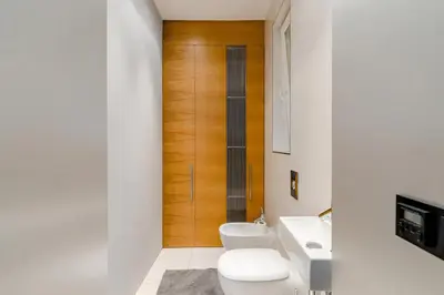 a bathroom with two toilets and a wooden door at Prague Days - One-bedroom Apartment with Workspace and iMac in Vinohrady in Prague