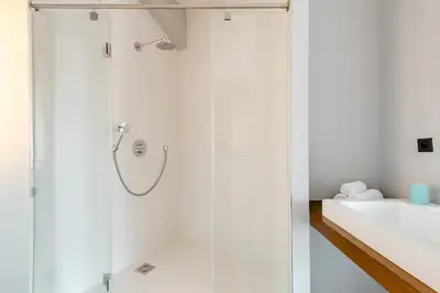 a shower with a glass door in a bathroom at Prague Days - One-bedroom Apartment with Workspace and iMac in Vinohrady in Prague