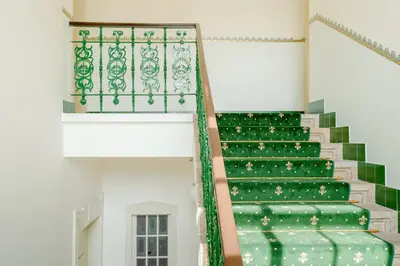 a green staircase in a building with a window at Prague Days - One-bedroom Apartment with Workspace and iMac in Vinohrady in Prague