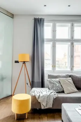 a living room with a couch and a yellow stool at Prague Days - One-bedroom Apartment with Workspace and iMac in Vinohrady in Prague