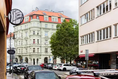 a street with cars parked in front of a building at 4 Trees Apartments by Adrez in Prague