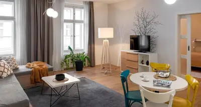 a living room with a couch and a table and chairs at 4 Trees Apartments by Adrez in Prague