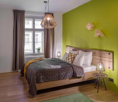 a bedroom with a bed and a green wall at 4 Trees Apartments by Adrez in Prague