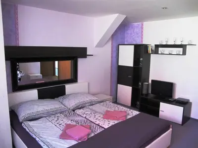a small bedroom with a bed with a mirror at Hotel U Lišky in Hošťka
