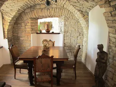 a dining room with a table and a stone wall at Hotel U Lišky in Hošťka