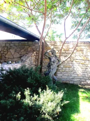 a statue of a man leaning against a stone wall at Hotel U Lišky in Hošťka