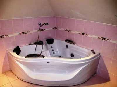 a bath tub in a pink tiled bathroom at Hotel U Lišky in Hošťka