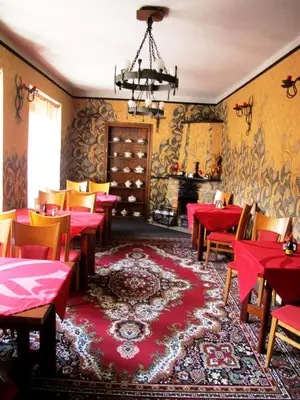 a restaurant with red tables and chairs and a fireplace at Hotel U Lišky in Hošťka