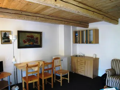a living room with a table and chairs and a sink at Hotel U Lišky in Hošťka