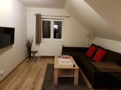 a living room with a black couch and a table at Apartments Anna and Ondra in Prague