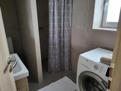 a bathroom with a washing machine and a shower curtain at Apartments Anna and Ondra in Prague
