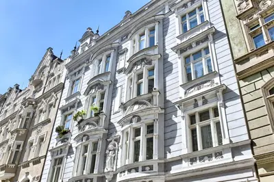 a large white building with windows on a street at Maiselova 5 Apartment in Prague