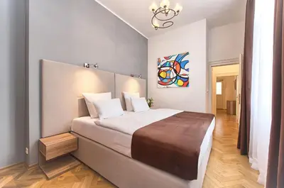 a bedroom with a large bed and a painting on the wall at Maiselova 5 Apartment in Prague
