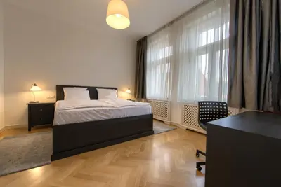 a bedroom with a bed and a desk and a window at Milosrdnych Apartments in Prague
