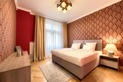 a bedroom with a bed and a red wall at Milosrdnych Apartments in Prague