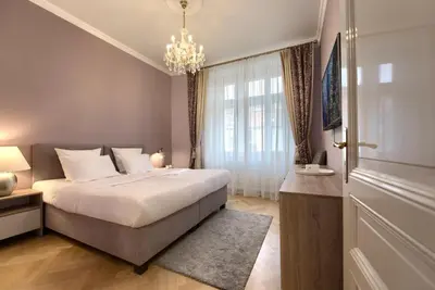 a bedroom with a large bed and a chandelier at Milosrdnych Apartments in Prague