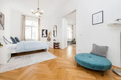 a bedroom with a bed and a blue ottoman at Quiet Apartment in The Old Town in Prague