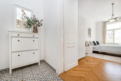 a white bedroom with a dresser and a bed at Quiet Apartment in The Old Town in Prague