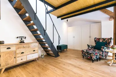 a living room with a staircase and a chair at The Old Town Square & Parizska Apartments in Prague