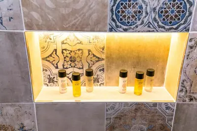 a shelf with four bottles of hair products on a wall at The Old Town Square & Parizska Apartments in Prague