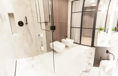 a bathroom with a toilet and a glass shower at Residence Glamour Premium in Prague