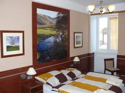 a bedroom with a bed and a painting on the wall at Penzion Mánes in Krabčice