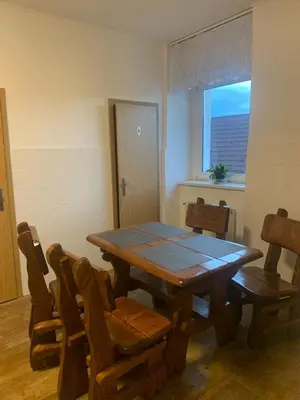 a dining room with a wooden table and chairs at Penzion Mánes in Krabčice