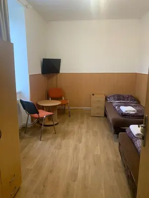 a room with a bed and a table and chairs at Penzion Mánes in Krabčice